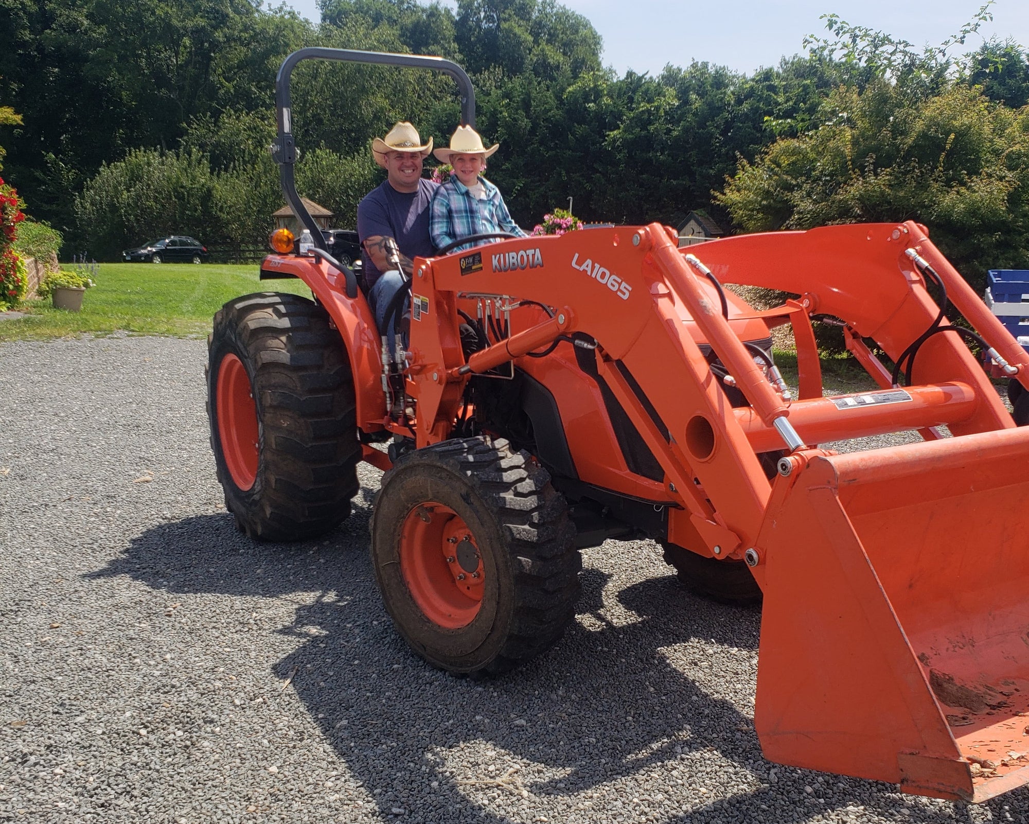 Person operating a red Kubota tractor